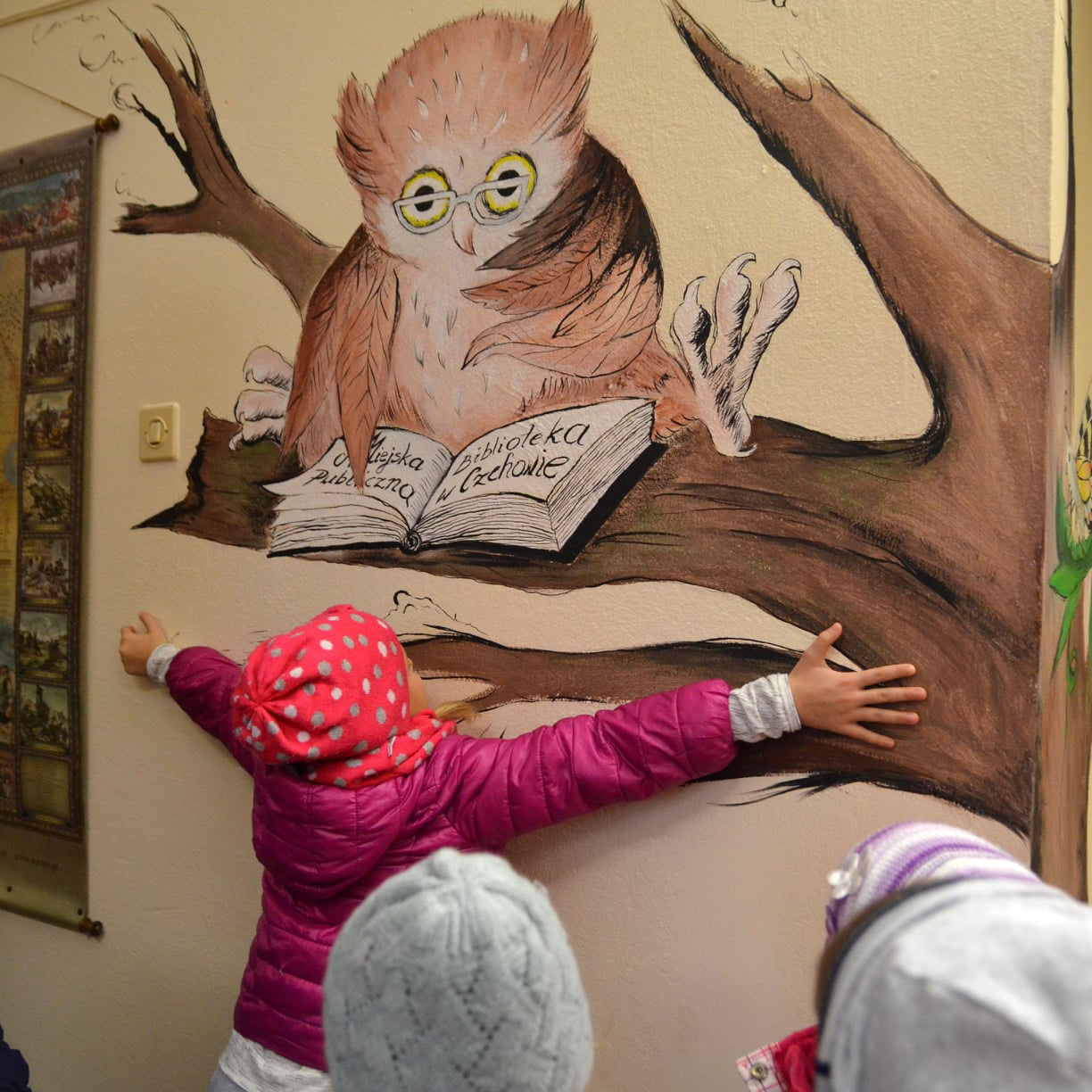 Drugi kadr muralu w bibliotece, stosy książek i motywy literackie