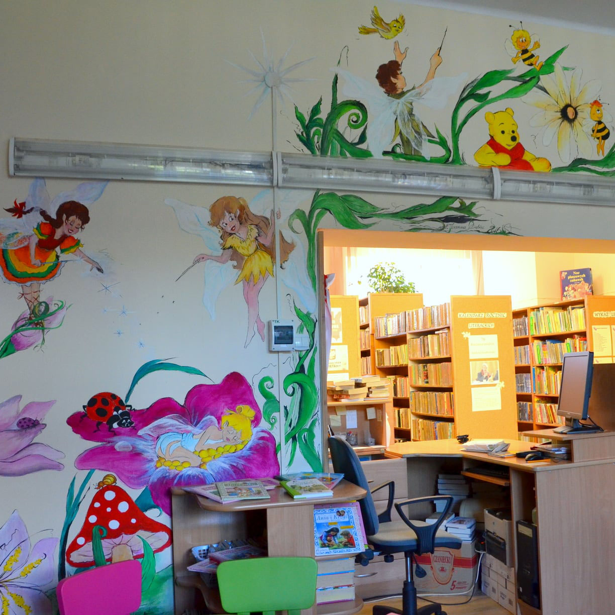 Czwarty kadr muralu w bibliotece z dekoracyjnymi elementami i motywami książkowymi